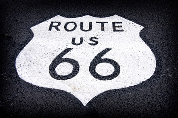aged and worn vintage photo of route 66 sign on the road