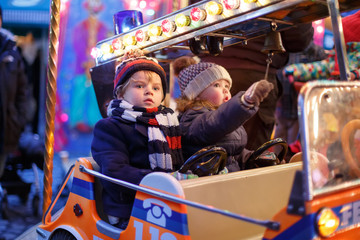 Little boy and girl on a carousel at Christmas market