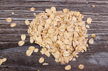 Heap of oat flakes on wooden background