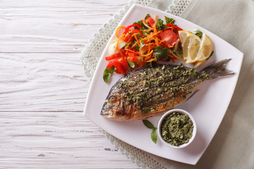 Grilled dorado fish with pesto and vegetable salad. Horizonta top view
