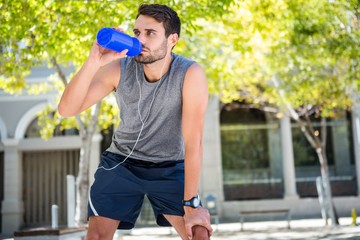 Handsome runner drinking fresh water