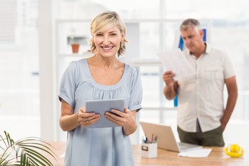 Obraz premium Smiling businesswoman holding a tablet