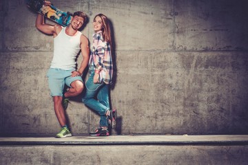 Obraz na płótnie Canvas Young couple with skateboard outdoors