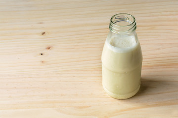 Bottle of fresh milk on wooden table