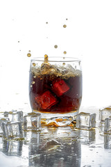 Ice cube droped in cola glass and cola splashing
