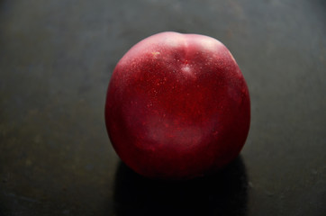 Fototapeta na wymiar nectarine fruit on a dark background in the center closeup