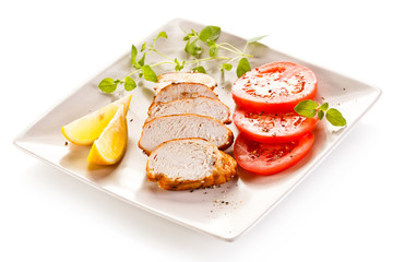Roast chicken fillet and vegetables on white background 
