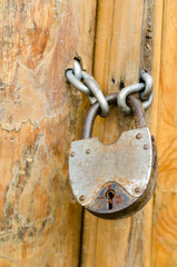 Old rustic padlock on the wooden door