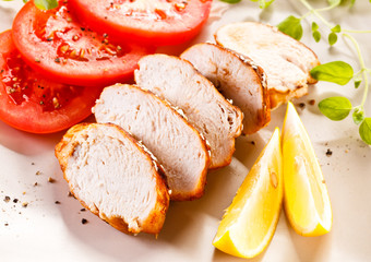 Roast chicken fillet and vegetables on white background 