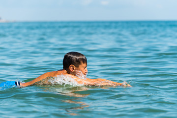 Ten year old boy teenager swims in the sea