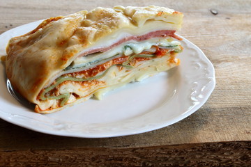 Lasagna with meat sauce, salami, spinach and alfredo sauce.