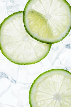 green lime slices on the ice cubes, top view