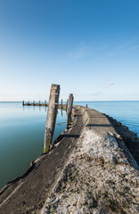 Obraz premium Old jetty with wooden bollards on a windless day