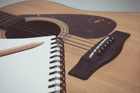 Pencil and paper on guitar in vintage