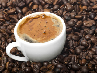 White cup on coffee beans background