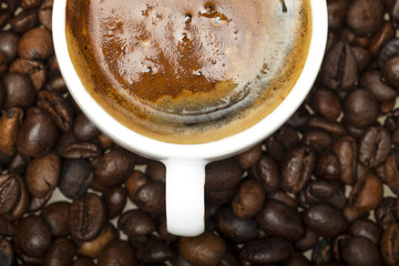 White cup on coffee beans background