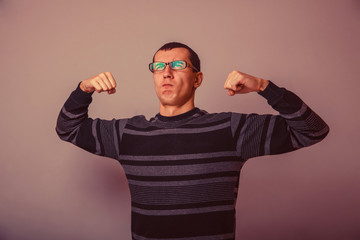 Naklejka premium European-looking male of about thirty brunet shows muscle streng