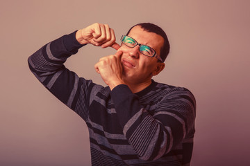 European-looking male of about thirty brunet squeezing a pimple 