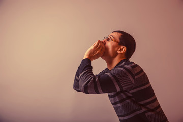 European-looking male put his hands to his mouth, shouting on gr