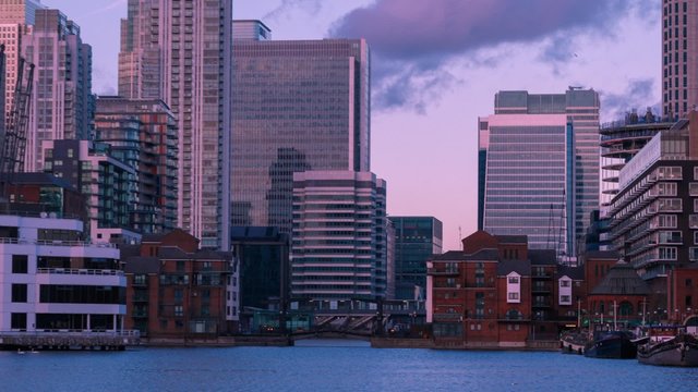 A hyperlapse motion view of London England Docklands shot from the Millwall Dock after sunset. Canary Wharf can be seen in the background.
