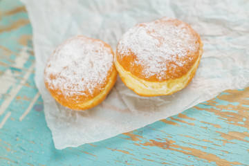 Sweet sugary donuts on rustic table