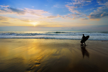 Fototapeta premium surfer entering water at sunset