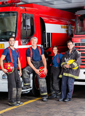 Fototapeta premium Confident Firefighters Leaning On Trucks