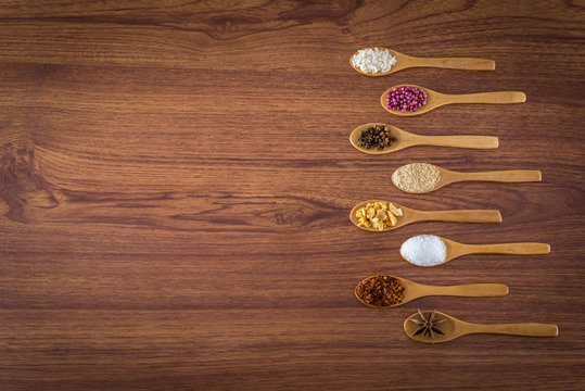 spice and herb in spoons on wooden background.