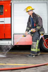 Firefighter Spraying Water On Floor During Training