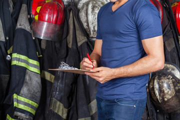 Obraz premium Fireman Writing On Clipboard
