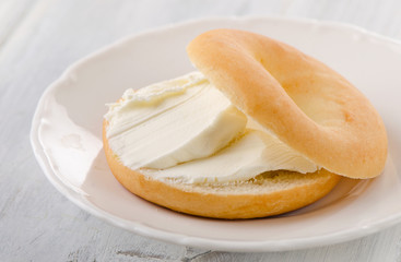 Naklejka na ściany i meble A plate with sliced bagel and cream cheese.
