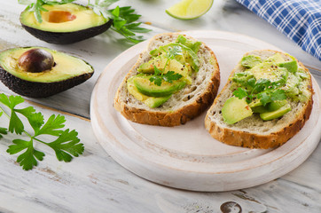 Homemade healthy sandwiches with avocado and herbs.
