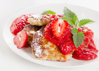 Cottage cheese pancakes with strawberry jam and mint leaves.