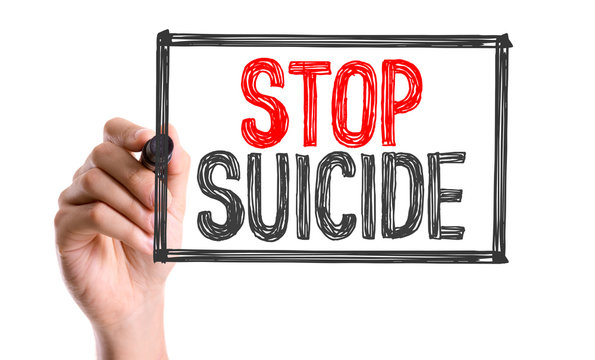 Hand with marker writing the word Stop Suicide