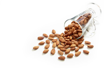 Almonds in the glass and pour on white background, selective focus point