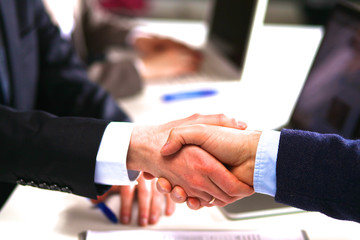 Business people handshake, sitting at the table
