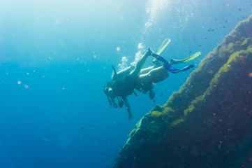 Scuba Diver on coral reef in clear blue water