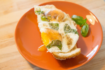 Fried egg with basil on a roll