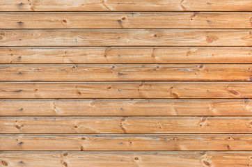 Larch wooden planks on the building facade covered with preventive impregnation