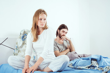 young caucasian couple in bed discussing their problems