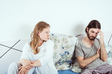 young caucasian couple in bed discussing their problems