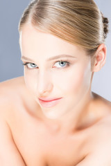 Obraz na płótnie Canvas Beautiful young woman with blue eyes on grey background.