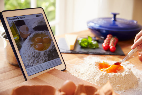 Person Following Pasta Recipe Using App On Digital Tablet