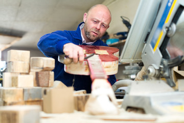 Concentrated artisan making guitar