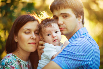 Fototapeta premium parents withshaggy baby son, close-up, summer