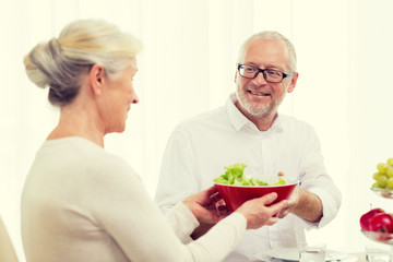 smiling senior couple having dinner at home