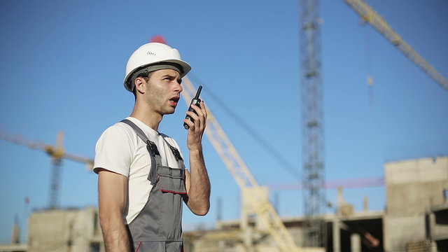 Сonstruction engineer builder using a walkie talkie radio giving instructions
