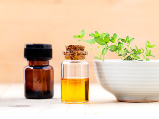 Bottle of essential oil and lemon thyme  leaf  on wooden backgro