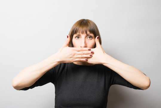 woman covering her mouth with her hand, quietly