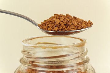 Spoon with a granular coffee jar over